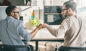 Two people sat on a chair at a desk